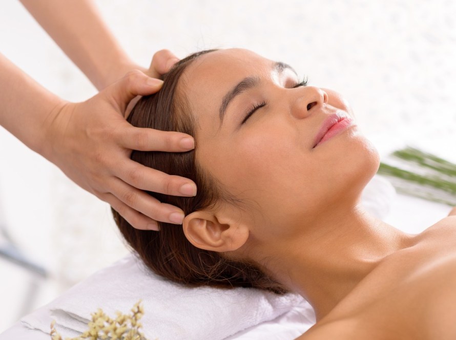 Client receiving the Pacific Scalp & Body Ritual in Pacific Beach, San Diego, with full body massage, heated scalp treatment and relaxing head massage