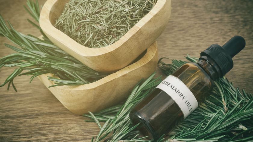 flat lay of essential oils, and dried herbs on a wooden table with natural light -- ideal for mood-boosting aromatherapy