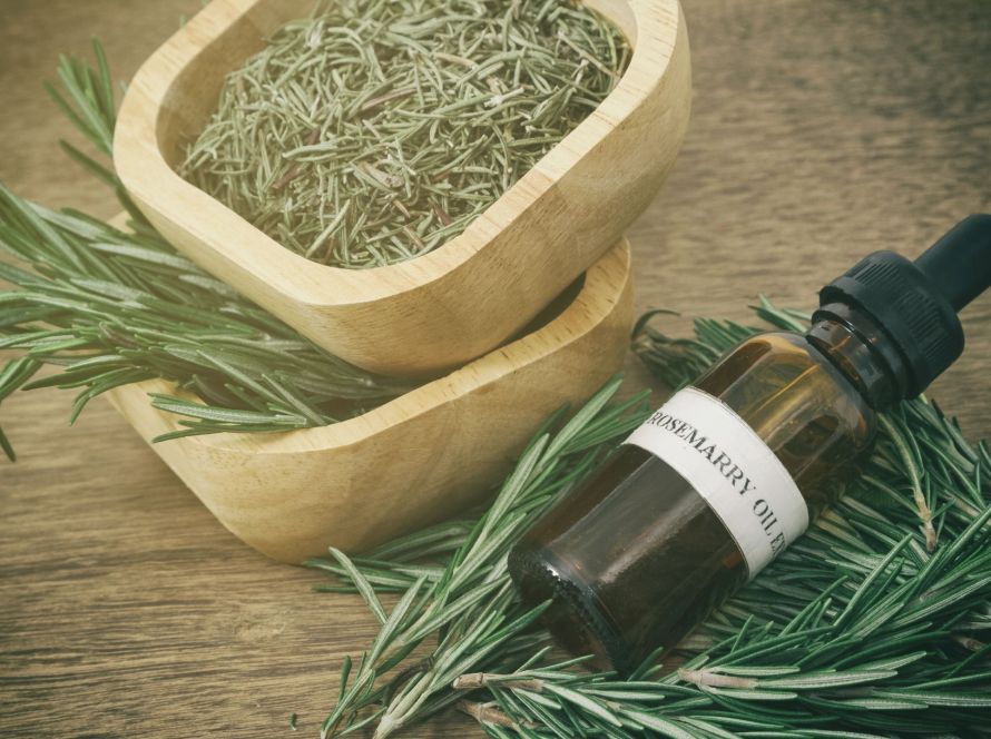 flat lay of essential oils, and dried herbs on a wooden table with natural light -- ideal for mood-boosting aromatherapy