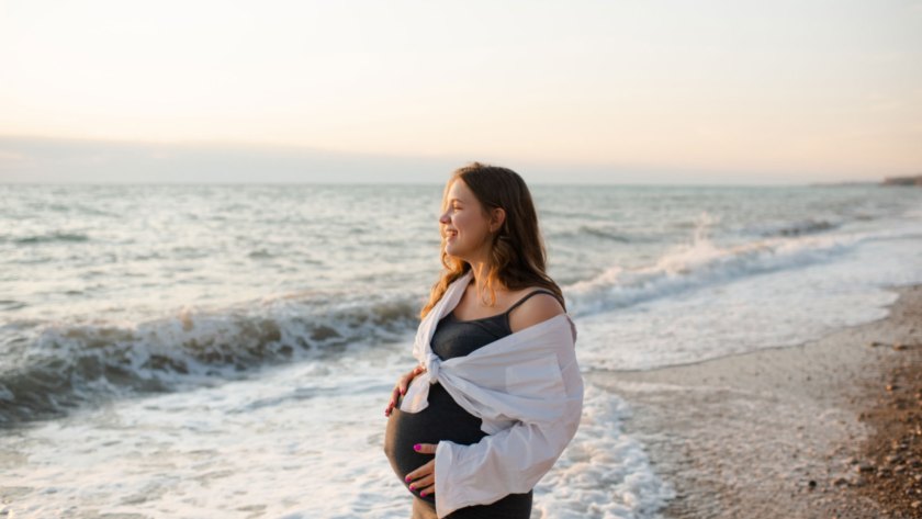 Pregnant woman in Pacific Beach reminiscing about her massage and enjoying the waves with the sunset.