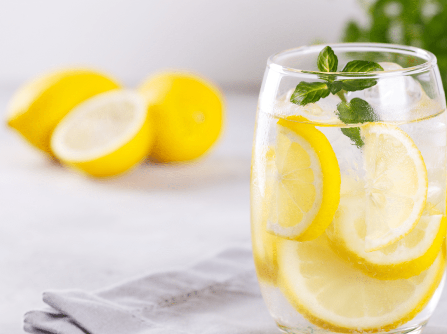Glass of fresh lemon water on a sunlit table, symbolizing hydration and detox naturally in Pacific Beach.